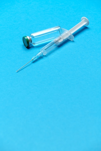 Zdjęcie strzykawka i ampułki z lekami lub szczepionką na niebiesko