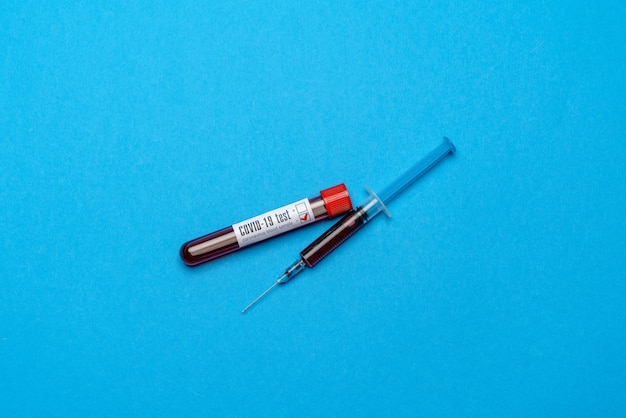 Strzykawka I Plastikowa Probówka Z Próbką Krwi na Niebiesko