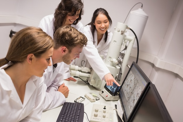 Zdjęcie studenci biochemii przy użyciu dużego mikroskopu i komputera