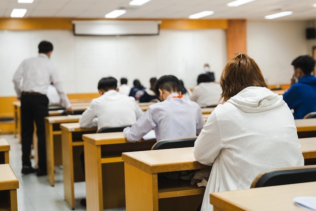 Zdjęcie studenci piszący w klasie na egzaminach końcowych w skupieniu