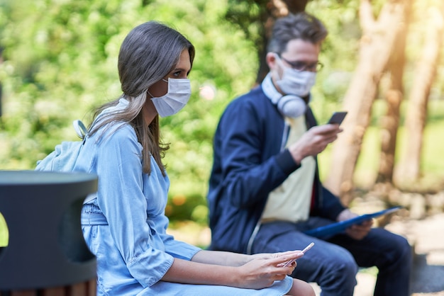 Studenci spędzający czas na terenie kampusu noszący maski ochronne i utrzymujący dystans z powodu pandemii koronawirusa