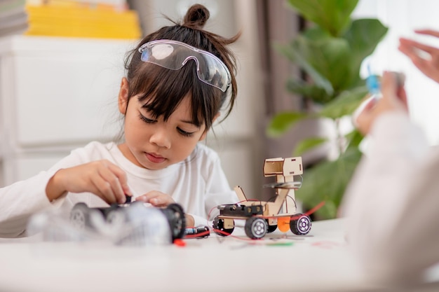 Studenci z Azji uczą się w domu kodowania samochodów robotów i kabli elektronicznych w STEM STEAM matematyka inżynieria nauka technologia kod komputerowy w koncepcji robotyki dla dzieci