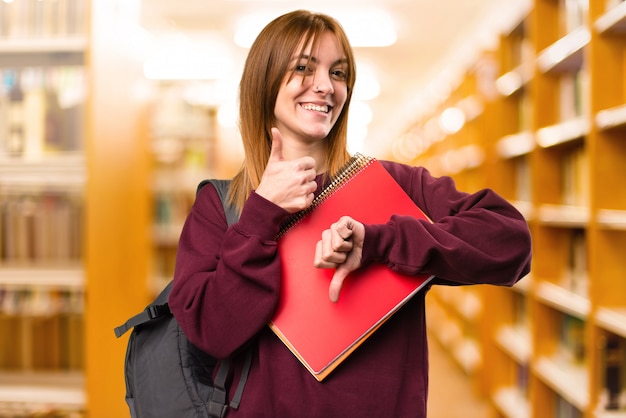 Studencka kobieta robi bad-bad znakowi na unfocused tle. powrót do szkoły