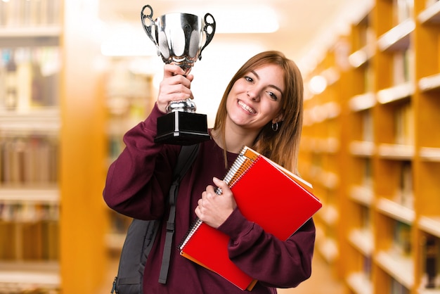 Zdjęcie studencka kobieta trzyma trofeum na unfocused tle. powrót do szkoły