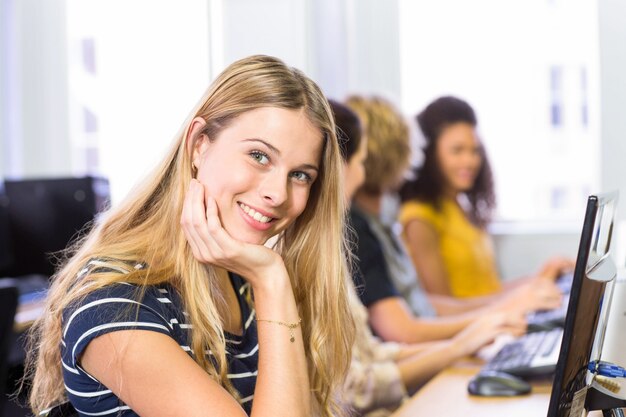 Studencki ono uśmiecha się przy kamerą w komputer klasie