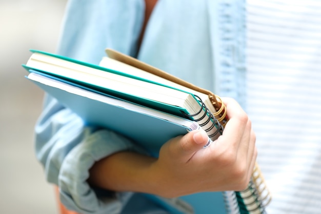 Studenckie Dziewczyny Ręki Mienia Książki I Niosą Szkolną Torbę Podczas Gdy Chodzący W Szkolnym Tle, E