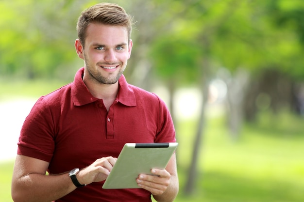 Student Patrząc Na Kamery, Trzymając Tablet Z Miejsca Na Kopię