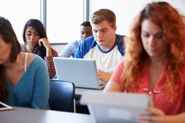 Student płci męskiej korzystający z laptopa w klasie