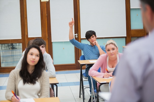 Student podnosząc rękę, aby zadać pytanie