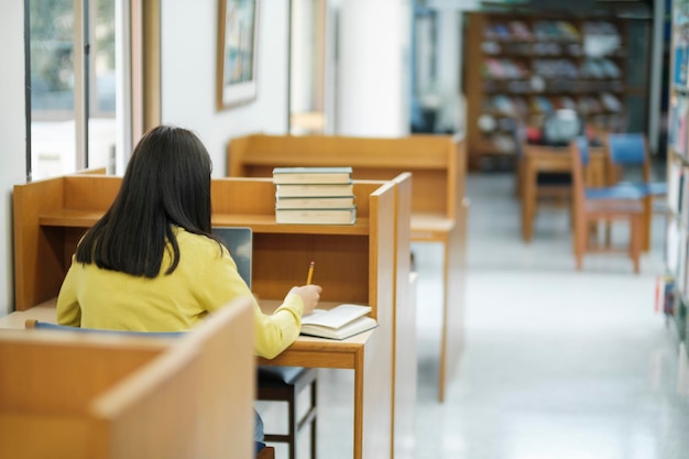 Student siedzi i studiuje w bibliotece