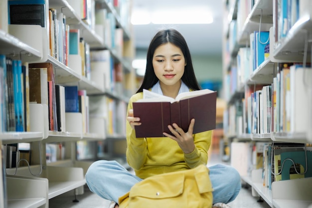 Student Siedzi Na Podłodze I Czyta W Bibliotece