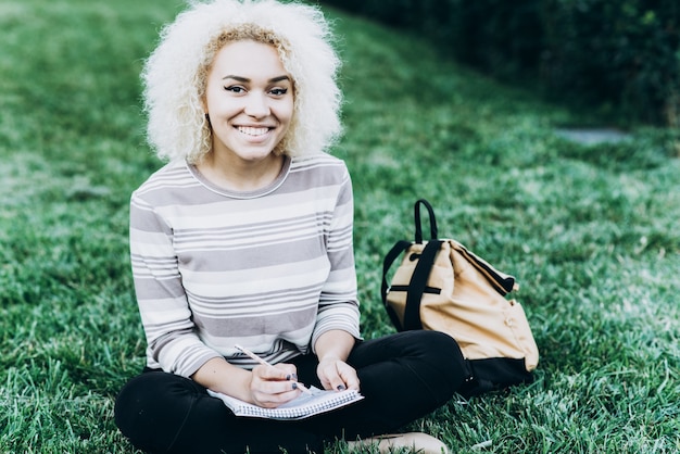 Student studiuje na świeżym powietrzu na trawie