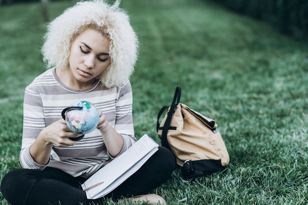 Zdjęcie student studiuje na świeżym powietrzu na trawie