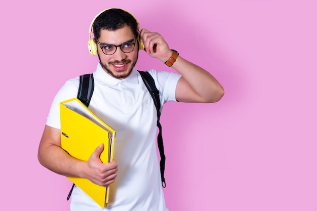 Student uniwersytetu z folderem plecaka i słuchawkami bezprzewodowymi