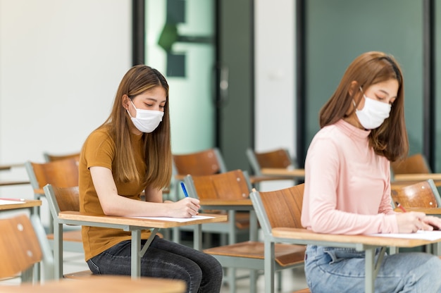 Student w masce siedzi w klasie uniwersytetu.