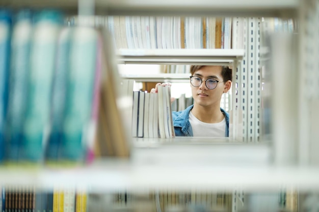 Student Wybiera I Czyta Książkę W Bibliotece