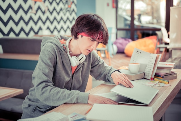 Student zamykający komputer. Student kończy pracę nad swoją pracą szkoleniową