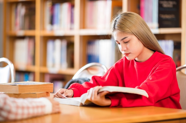 Studentka Czytająca Książkę W Bibliotece Uniwersyteckiej