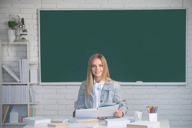 Studentka na wykładzie lekcyjnym w klasie w liceum lub na studiach uśmiechnięta studentka czytająca książkę