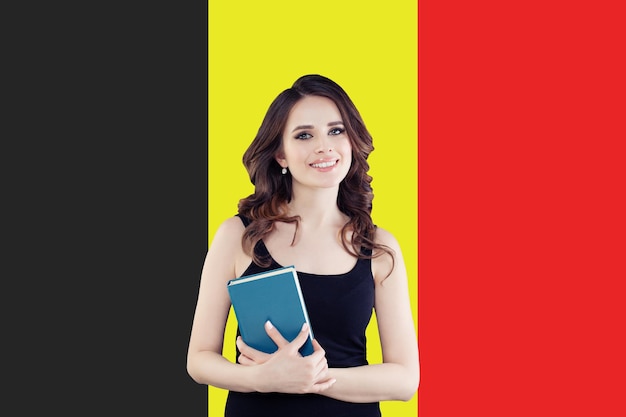 Studia w Belgii Szczęśliwa inteligentna studentka na tle belgijskiej flagi
