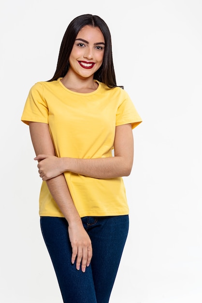Studio fotografii brazylijskiej kobiety w eleganckiej żółtej bluzce i uśmiechniętej na białym tle. Piękna modelka z białym tłem.