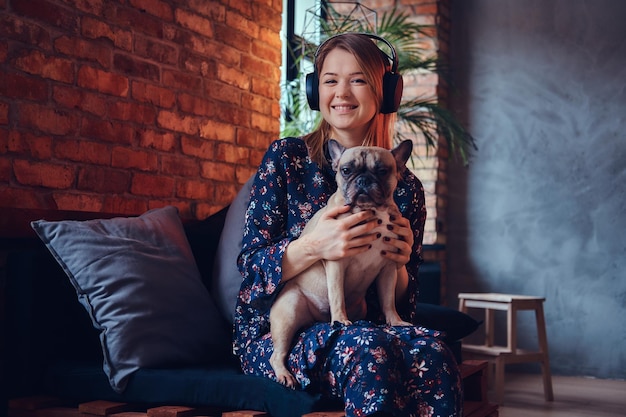 Studio portret atrakcyjna szczęśliwa blondynka w pokoju z wnętrzem na poddaszu.