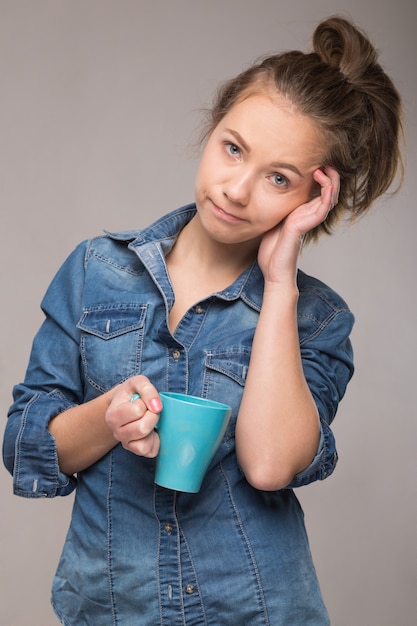 Studio Portret śpiącej Kobiety W Pomarańczowej Koszuli Z Filiżanką Kawy W Ręku