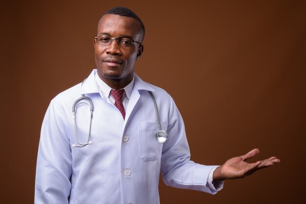 Studio strzałów młodego lekarza afrykańskiego człowieka na brązowym tle