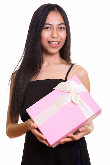 Studio strzałów młodych szczęśliwych azjatyckich nastoletnie dziewczyny uśmiechnięte trzymając prezent