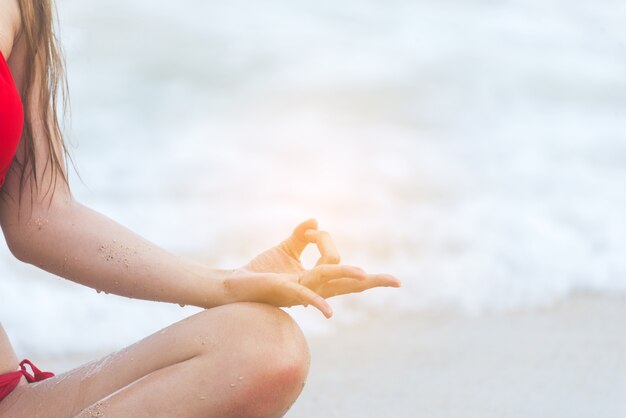 Styl życia fitness joga na plaży relaks zdrowej kobiety robi medytacji. Joga medytująca na świeżym powietrzu z zen w pozycji siedzącej. Oświecenie fitness koncepcja młodych ćwiczeń koncentratu szczęścia