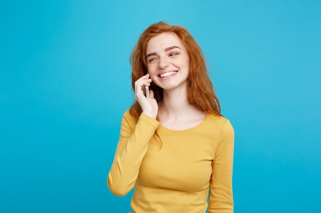 Styl życia i koncepcji technologii - Portret wesołej szczęśliwy imbir czerwony dziewczyna włosy z radosne i ekscytujące rozmawiać z przyjacielem przez telefon komórkowy. Pojedynczo na Niebieskim Tle Pastelowe. Skopiuj miejsce.