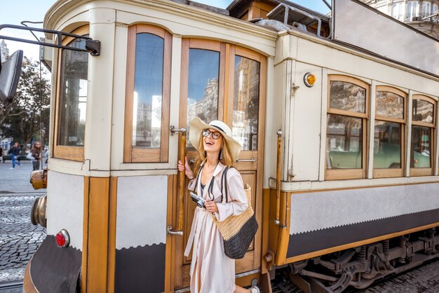 Styl życia portret kobiety w pobliżu słynnego starego tramwaju turystycznego na ulicy w mieście Porto, Portugalia