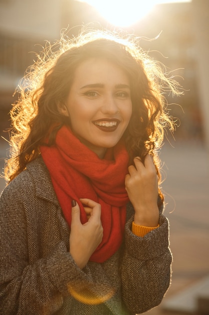 Styl życia portret modnie ubranej szczęśliwej kobiety noszącej vintage oversize płaszcz i czerwony szalik