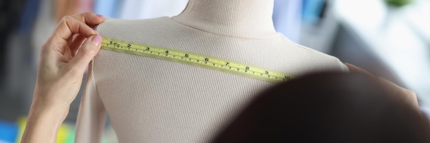 Stylistka projektantki mody mierzy ubrania na manekinie