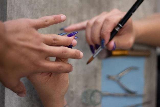 Stylistka wykonująca manicure na męskiej dłoni