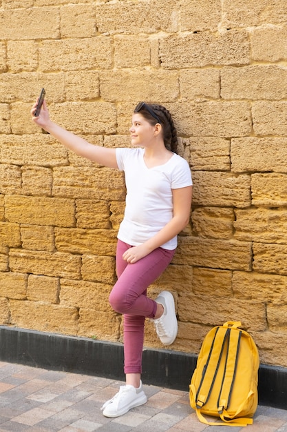 Stylowa Dziewczyna Nastolatka Bierze Selfie W Mieście Na Tle Kamiennego Muru