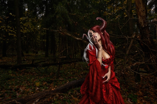 Stylowa i modna modelka dziewczyny na obrazie Maleficent pozującej wśród mistycznego lasu - bajkowa opowieść, cosplay. Halloween.
