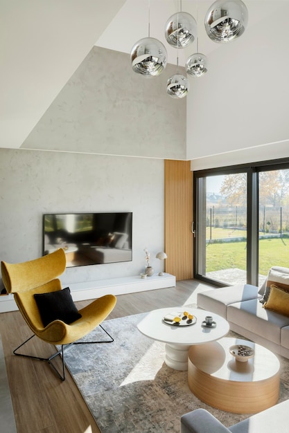 Zdjęcie stylowa kompozycja wnętrza salonu z narożną beżową sofą, żółtym fotelem, stolikiem kawowym i minimalistycznymi dodatkami. okno panoramiczne. szablon.