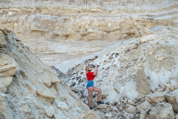 Stylowa młoda kobieta spaceru w piasku skały w upalny letni dzień, wakacje