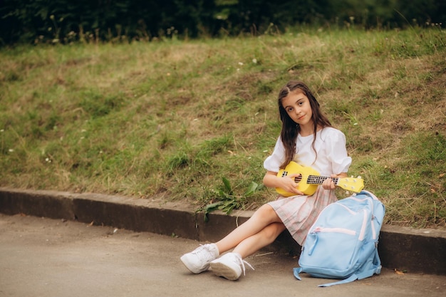 stylowa modna mała rockowa dziewczynka z gitarowymi wielobarwnymi warkoczami z kanekalon Zdjęcie wysokiej jakości