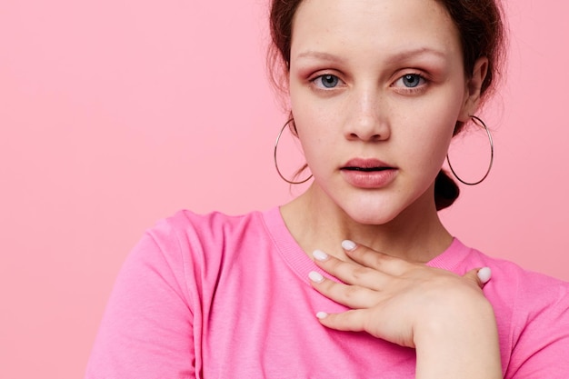 Stylowa nastolatka modelka w różowej koszulce młodzieżowej na białym tle niezmienione