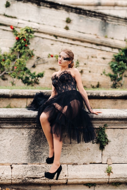 Stylowa panna młoda w czarnej sukni ślubnej pozuje w starożytnym francuskim mieście Awinion