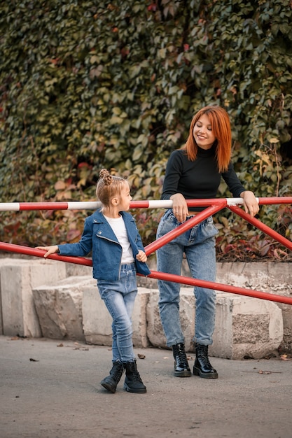 Stylowa Rudowłosa Mama I Córka Rozmawiają Ciepło. Szczęśliwe Dziecko I Jej Mama Na Ulicy. Udana Samotna Matka Z Córką Na Spacer. Ciepłe Relacje Rodzinne