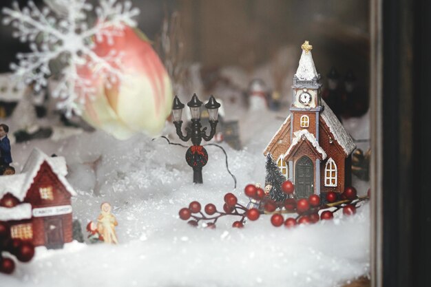 Stylowa świąteczna dekoracja małego miasta Budynek kościoła śnieg i latarnia miniatura miasta xmas