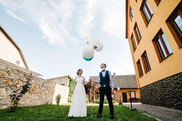 Stylowa Szczęśliwa Panna Młoda I Pan Młody Trzymaj Balony W Ręce.