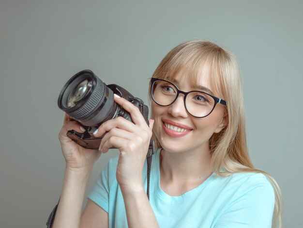 Stylowa Wesoła Kobieta Fotograf W Okularach I Trzymająca Aparat Fotograficzny