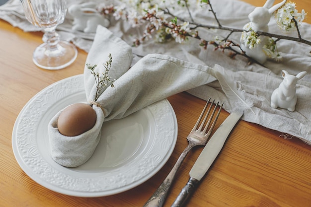 Stylowe nakrycie stołu na brunch wielkanocny Pisanka w króliczku serwetka sztućce króliczek kwiaty