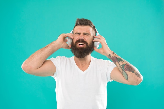 Stylowy i przystojny meloman Mężczyzna w słuchawkach Darmowe źródła muzyki online działają trochę inaczej i mają wiele różnych funkcji Wykres muzyczny Dojrzały hipster z brodą słuchający muzyki