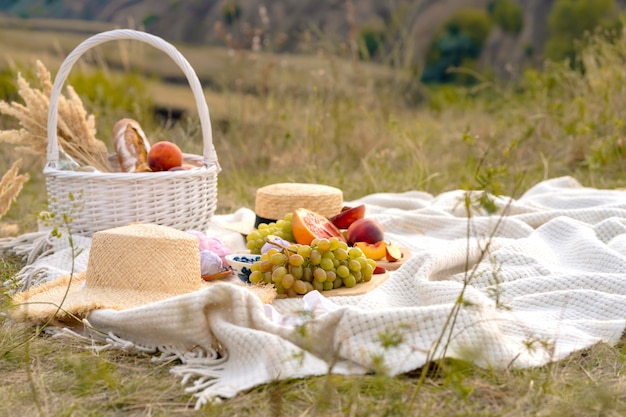 Stylowy letni piknik na białym kocu. W malowniczym miejscu charakter wzgórz.