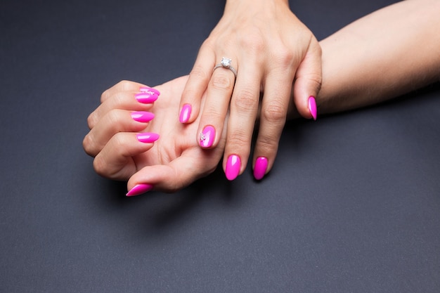 Stylowy manicure różowy na czarnym tle